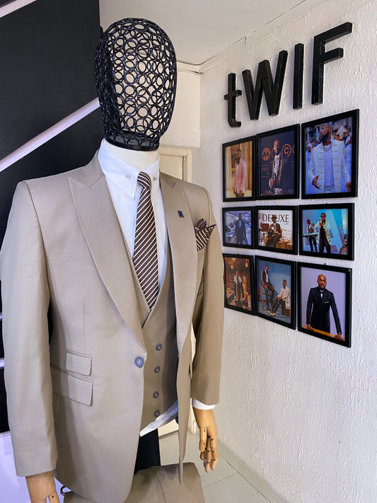 A light brown three piece peak lapel suit